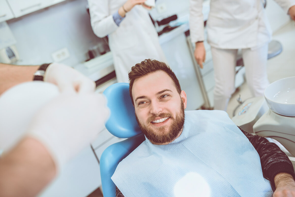 bearded man smiles in dental chair