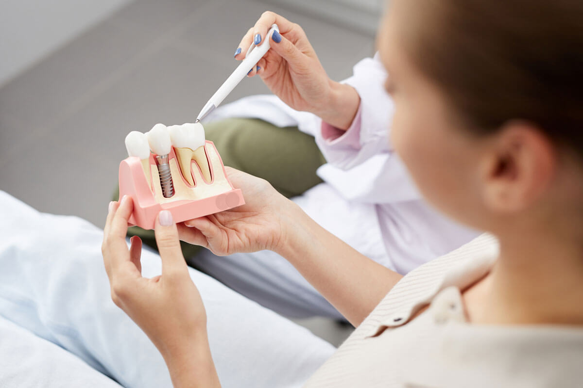 patient holding a model of a dental implant